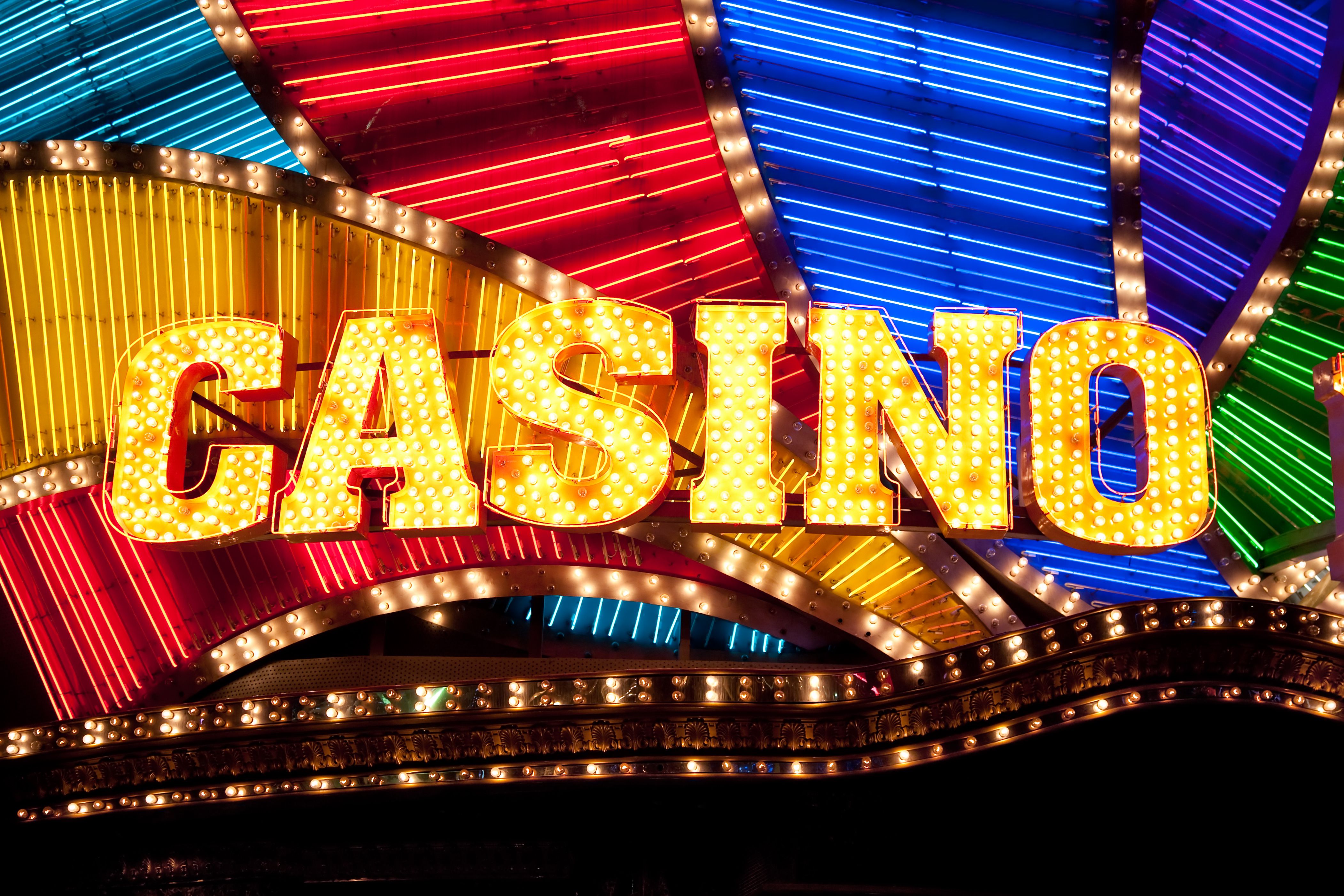 A dynamic graphic showing various real money casino games and stacks of coins and cash.